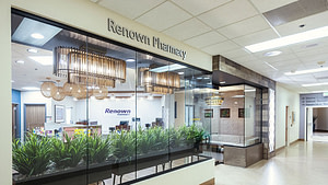 Storefront of Renown Pharmacy Reno with grasses in the window and gold lights hanging from the ceiling.