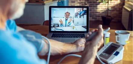 Patient using telehealth to send vitals to their doctor via computer.
